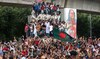 Protesters climb a public monument as they celebrate the news of Prime Minister Sheikh Hasina’s resignation, in Dhaka.