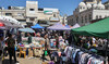 Palestinians shop at a market in Ramallah, in the occupied West Bank on April 19, 2024. (AFP)