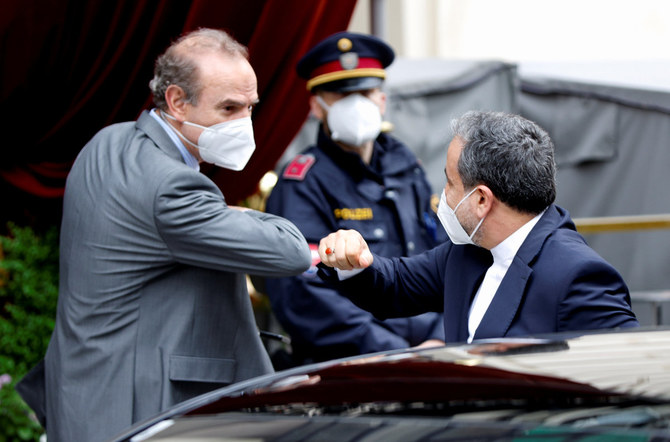 Iran Deputy FM Abbas Araghchi bumps elbows with EU official Enrique Mora in front of a hotel in Vienna where a meeting to discuss the Iran nuclear deal was held on May 25, 2021. (Reuters)