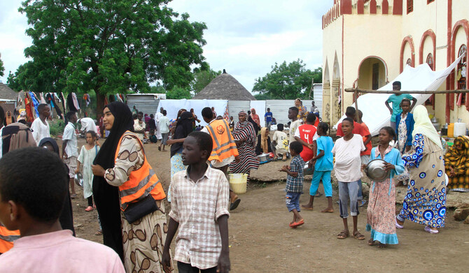 Sudanese, displaced from the town of Sinjah, receive humanitarian aid at their makeshift camp in Gedaref on Aug. 22, 2024. (AFP)